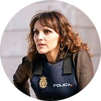 Ines Villegos has curly, brown hair and is wearing a police vest